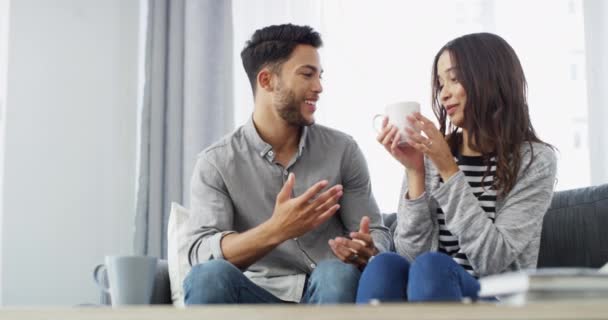 Home, coffee and couple on a couch, conversation and marriage with happiness, love and bonding together. Apartment, romance and man with woman on a sofa, tea and latte with joy, relax or relationship. - Footage, Video