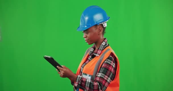 Tablet, retrato de tela verde ou mulher negra construtor com polegares para cima ou espaço mockup na indústria da construção. Empreiteira africana, fundo de estúdio ou trabalhador da construção feliz do sexo feminino sorrindo com capacete. - Filmagem, Vídeo
