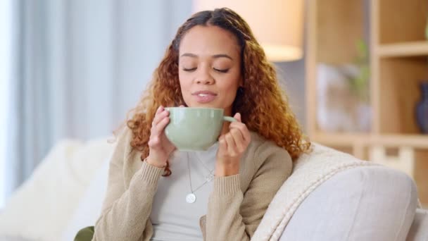Donna che beve una tazza calda di tè o caffè a casa. Giovane donna spensierata, rilassata e allegra che sente l'aroma di una bevanda calda fresca sorseggiando un sorso e godendo di una comoda pausa a casa.. - Filmati, video
