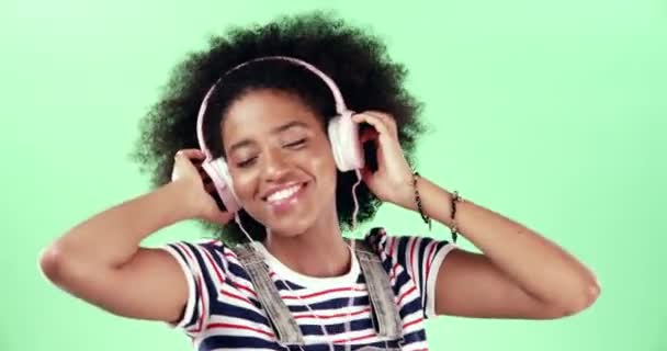 Groen scherm, koptelefoon en vrouw of muziek, dans en streaming radio of gelukkig. Zwarte vrouwelijke persoon, podcast en gehoor audio of lied, afspeellijst en geluid voor energie, verbinden en opgewonden voor vrijheid. - Video