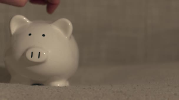 Χέρι βάζοντας τα κέρματα σε Piggy αποταμιεύσεις τράπεζα κοντά 4k πυροβόλησε επιλεκτική εστίαση  - Πλάνα, βίντεο