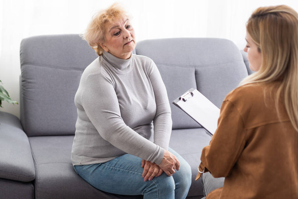 Κατάθλιψη ανώτερος γυναίκα μιλάει με θηλυκό ψυχολόγος. - Φωτογραφία, εικόνα