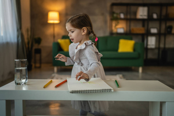 Toddler lány kaukázusi gyermek játszani zsírkrétákkal otthon - Fotó, kép