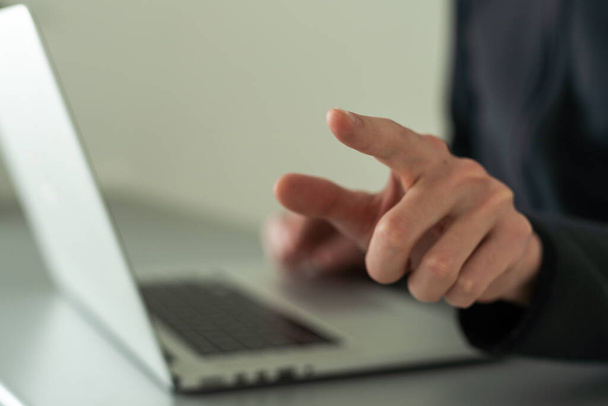 Палець вказує на екран ноутбука з важливими технологічними новинами. Бізнесмен натискає віртуальну кнопку на дисплеї - Фото, зображення