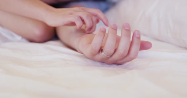 Пара, рука тримає і кохає в ліжку крупним планом для щасливого партнерства, романтики або святкування шлюбу. Люди, пальці та інтимні знайомства для пробудження вранці або зв'язку, розслабляють спокій або спокій. - Кадри, відео
