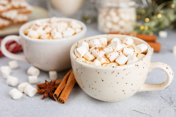 Hot drink with marshmallows and candy cane in cup on texture table.Cozy seasonal holidays.Hot cocoa with gingerbread Christmas cookies.Hot chocolate with marshmallow and spices.Copy space. - Photo, Image