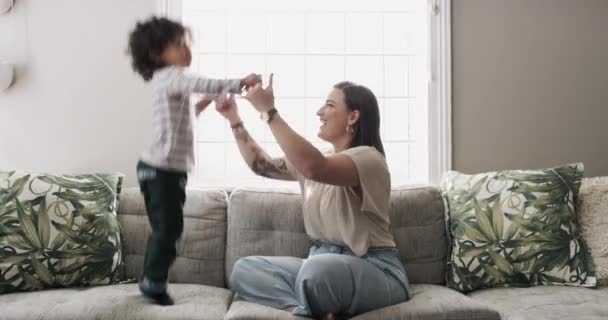 Jump, child or mom playing on sofa for fun games on family holiday or break to relax together. Holding hands, wellness or excited kid in home living room for happiness or bond with freedom or mother. - Footage, Video