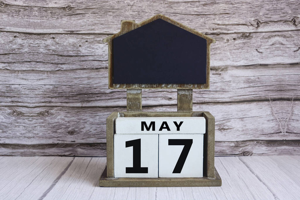 Chalkboard com data de calendário de 17 de maio no bloco de cubo branco na mesa de madeira. - Foto, Imagem