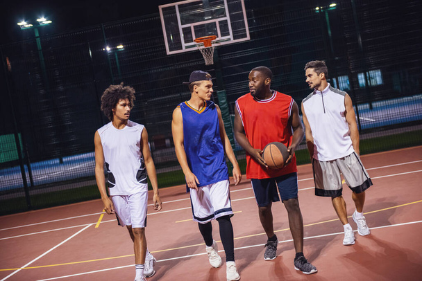 Przystojni faceci grają Koszykówka na zewnątrz w nocy - Zdjęcie, obraz