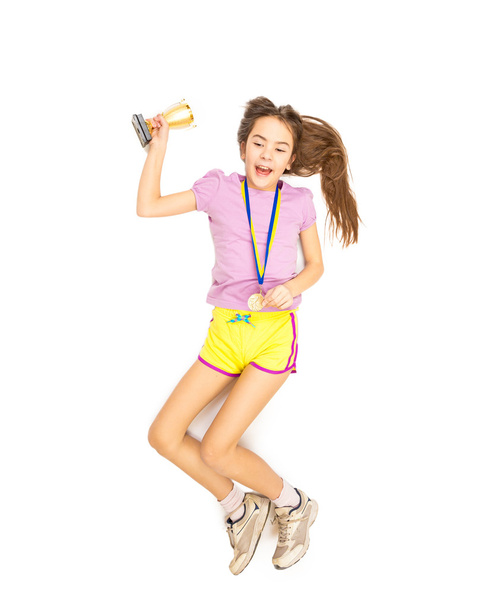 Jubelnde Mädchen springen hoch mit Goldmedaille und Pokal  - Foto, Bild