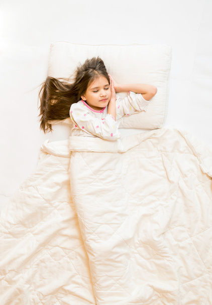 Απομονωμένες φωτογραφία από την κορυφή του χαριτωμένο κορίτσι στον ύπνο στο κρεβάτι - Φωτογραφία, εικόνα