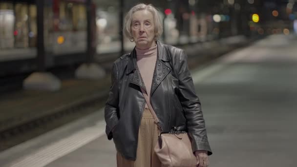 Bezorgde oudere vrouw wachtend bij drukke treinstation Reizend - Video