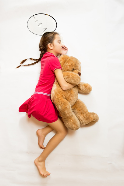 View from top view of dreaming girl lying on big teddy bear - Photo, Image