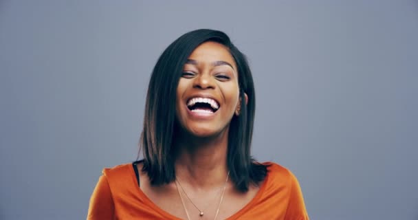 Face, studio or happy black woman laughing at joke or crazy comedy isolated on gray background. Girl hipster, funny lady or silly female person with pride, smile or goofy joy to relax with humor. - Footage, Video