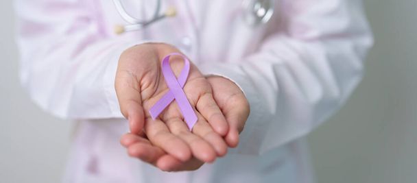 世界がんデー,ルプス,膵臓,精巣,精巣癌,世界のアルツハイマー,てんかん,サルコイドーシス,繊維筋痛および国内暴力意識月の概念のための紫のリボンを用いる医者 - 写真・画像
