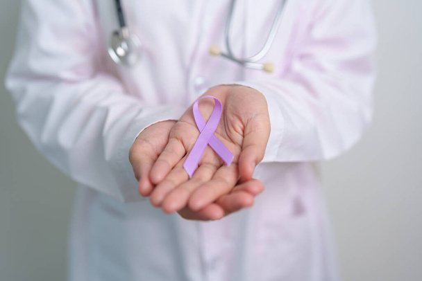 世界がんデー,ルプス,膵臓,精巣,精巣癌,世界のアルツハイマー,てんかん,サルコイドーシス,繊維筋痛および国内暴力意識月の概念のための紫のリボンを用いる医者 - 写真・画像