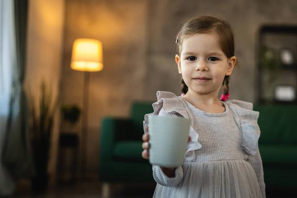 jeden maluch dziewczyna kaukaski dziecko trzymać szklankę wody napój w domu - Zdjęcie, obraz