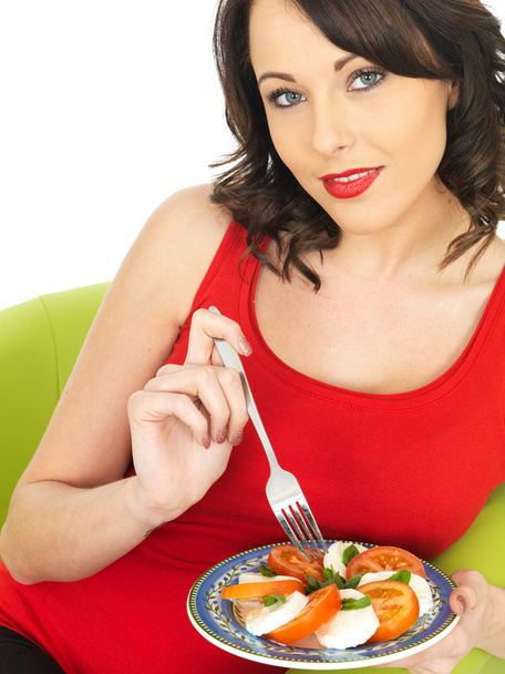 Mujer joven comiendo una ensalada de queso y tomate Mozzarella
 - Foto, imagen