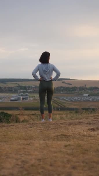 Girl runner feeling free and enjoying view of mountains. Woman standing on the hill after jogging. Adventure, sport, activity, wanderlust concept - Video