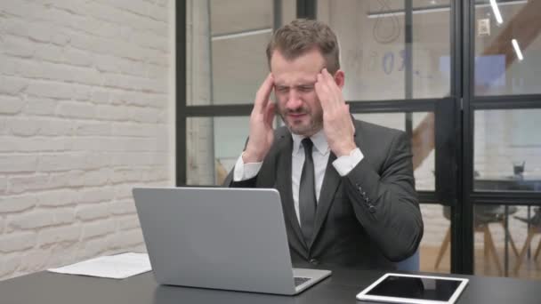 Uomo d'affari di mezza età che ha mal di testa al lavoro - Filmati, video