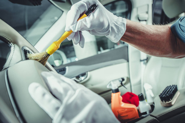 Caucasian Automotive Worker Cleaning Car Dashboard Using a Soft Brush - Photo, Image