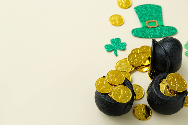 Pot with coins and paper decor on beige background. St. Patrick's Day celebration - Fotoğraf, Görsel