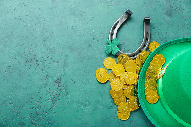Leprechaun hat with horseshoe, golden coins and paper clover on green grunge background. St. Patrick's Day celebration - Φωτογραφία, εικόνα