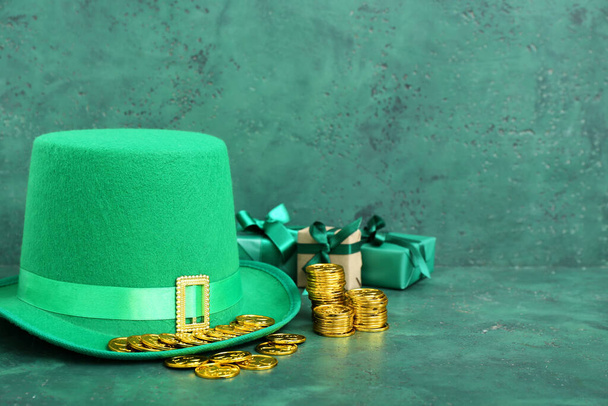 Leprechaun hat with golden coins and gifts on green grunge background. St. Patrick's Day celebration - Photo, Image