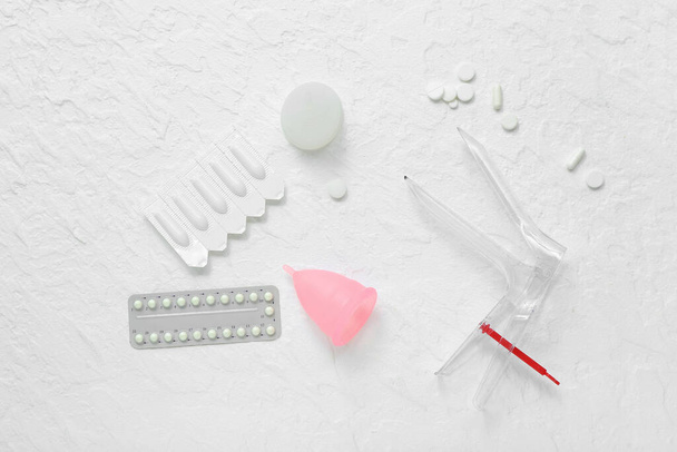 Gynecological speculum, pills, suppositories and menstrual cups on white background - Photo, Image