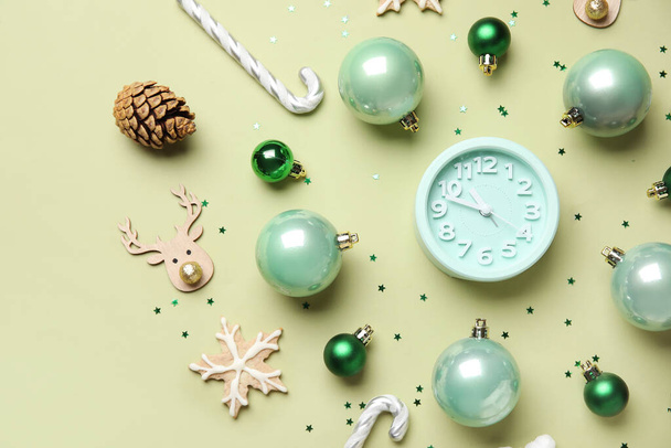 Reloj despertador con decoración navideña sobre fondo verde - Foto, Imagen