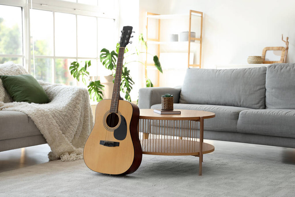 Interior of living room with sofas, table and guitar - Foto, afbeelding