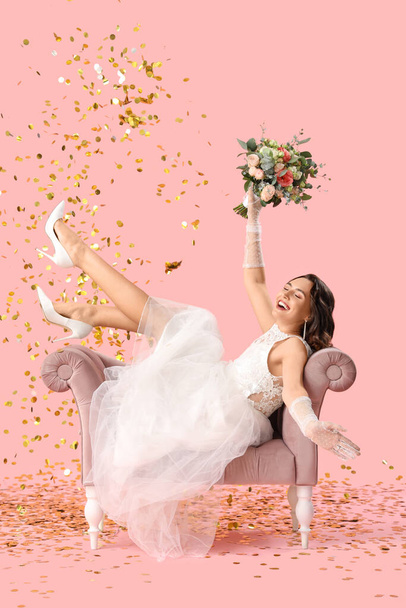 Beautiful bride with wedding bouquet in armchair and confetti on pink background - Foto, afbeelding