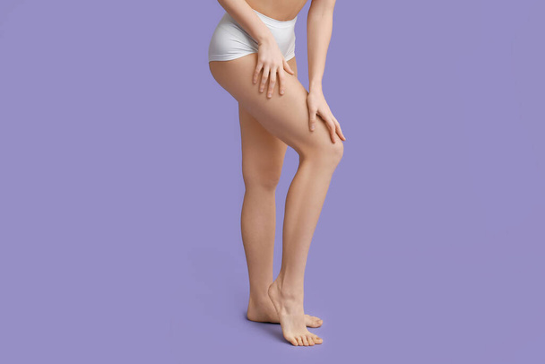 Beautiful young woman after depilation of legs on purple background, closeup - Foto, imagen
