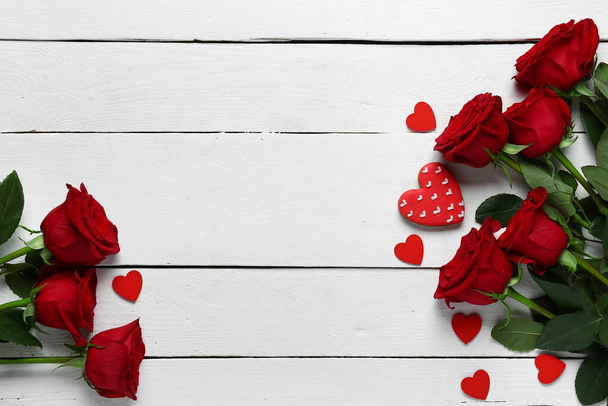 Red roses and hearts on white wooden background - Фото, изображение