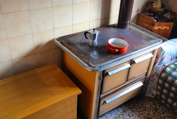 старинная дровяная печь экономичной кухни с мокой для приготовления кофе в домашних условиях на горячей чугунной пластине - Фото, изображение