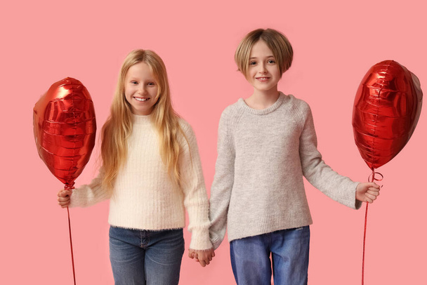 Little children with heart-shaped balloons on pink background. Valentine's Day celebration - Foto, Imagen