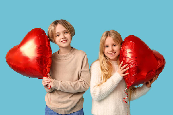 Little children with heart-shaped balloons on blue background. Valentine's Day celebration - 写真・画像
