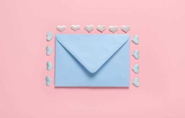 Composition with blue envelope and hearts on pink background. Valentine's Day celebration - Foto, Imagen