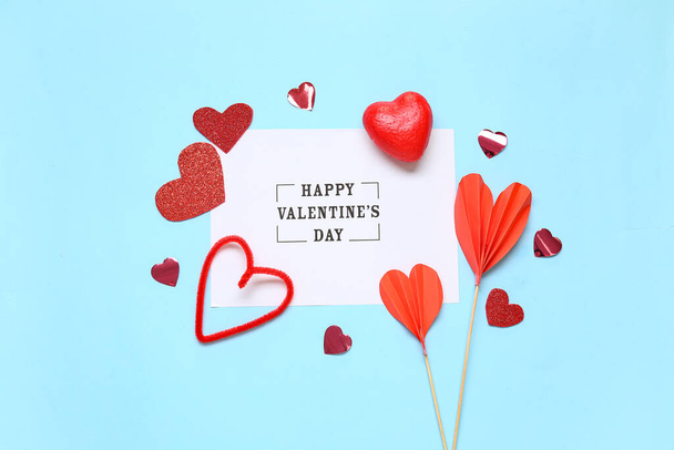 Kártya szöveges HAPPY VALENTINE nap és szív alakú dekoráció kék alapon - Fotó, kép