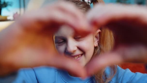 I love you. Child kid girl makes symbol of love, showing heart sign to camera, express romantic feelings, express sincere positive feelings. Charity, gratitude, donation. Female teen at night home - Footage, Video