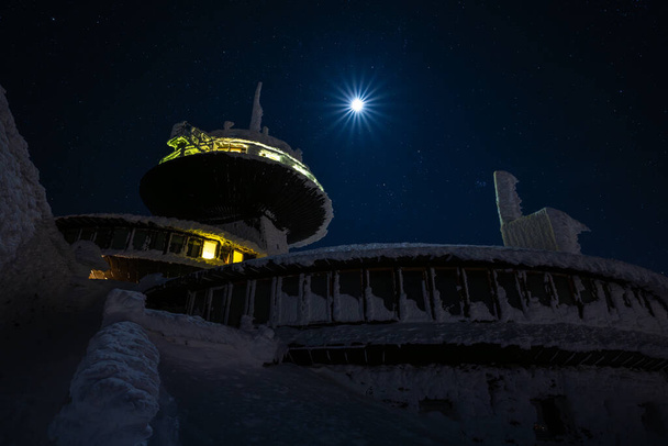 piek van de berg Sniezka bij volle maan 's nachts tijdens in Reuzengebergte tijdens de winter - Foto, afbeelding