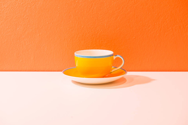 Чашка желтого кофе с оранжевой стеной, Таиланд. - Фото, изображение