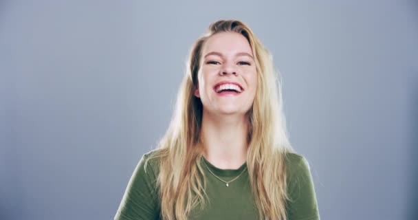 Mutlu, yüz ve kadın komik, komik ve aptalca şakalar için bir stüdyoda gülüyor. Gülümse, heyecanlı ve Avustralyalı genç kadın modelin portresi gri arka planda şapşal bir ifadeyle - Video, Çekim