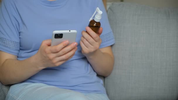 Женщина читает инструкции по применению лекарств в Интернете с помощью смартфона - Кадры, видео