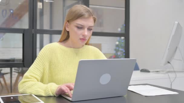 Opgewonden jonge blonde vrouw viert succes op laptop - Video