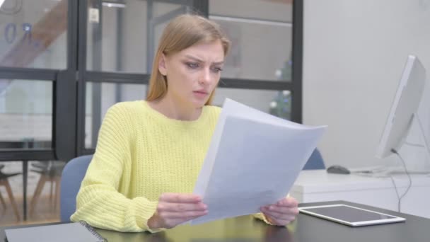 Jeune femme blonde se sentant bouleversé tout en lisant contrat - Séquence, vidéo