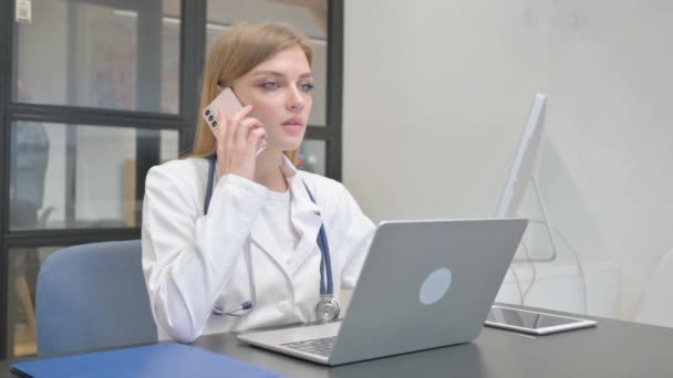 Γυναίκα γιατρός μιλάει στο τηλέφωνο στην εργασία - Πλάνα, βίντεο