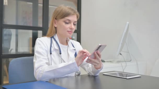 Kobieta Lekarz Korzystanie ze smartfona do przeglądania online - Materiał filmowy, wideo