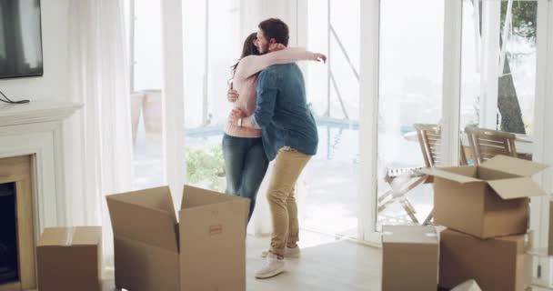 Šťastný pár, objetí a spin s krabicemi v novém domově po stěhování s nemovitostmi, investice do nemovitostí nebo kupní smlouvy. Muž, žena a ženatý s bezpečností ve vizi budoucnosti, rodiny a růstu. - Záběry, video