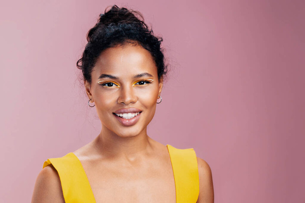 Femme copie visage cosmétique mode coloré maquillage cosmétologie jaune studio sourire créatif espace style beauté beau portrait peau noire modèle africain - Photo, image